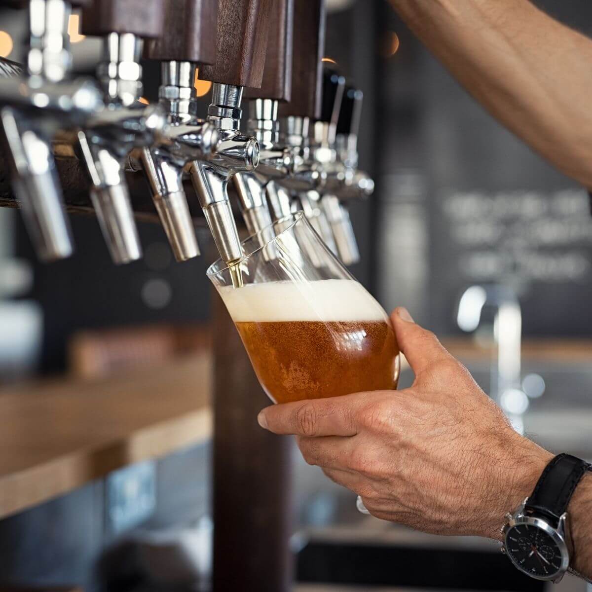 Person pouring beer from a tap into a glass